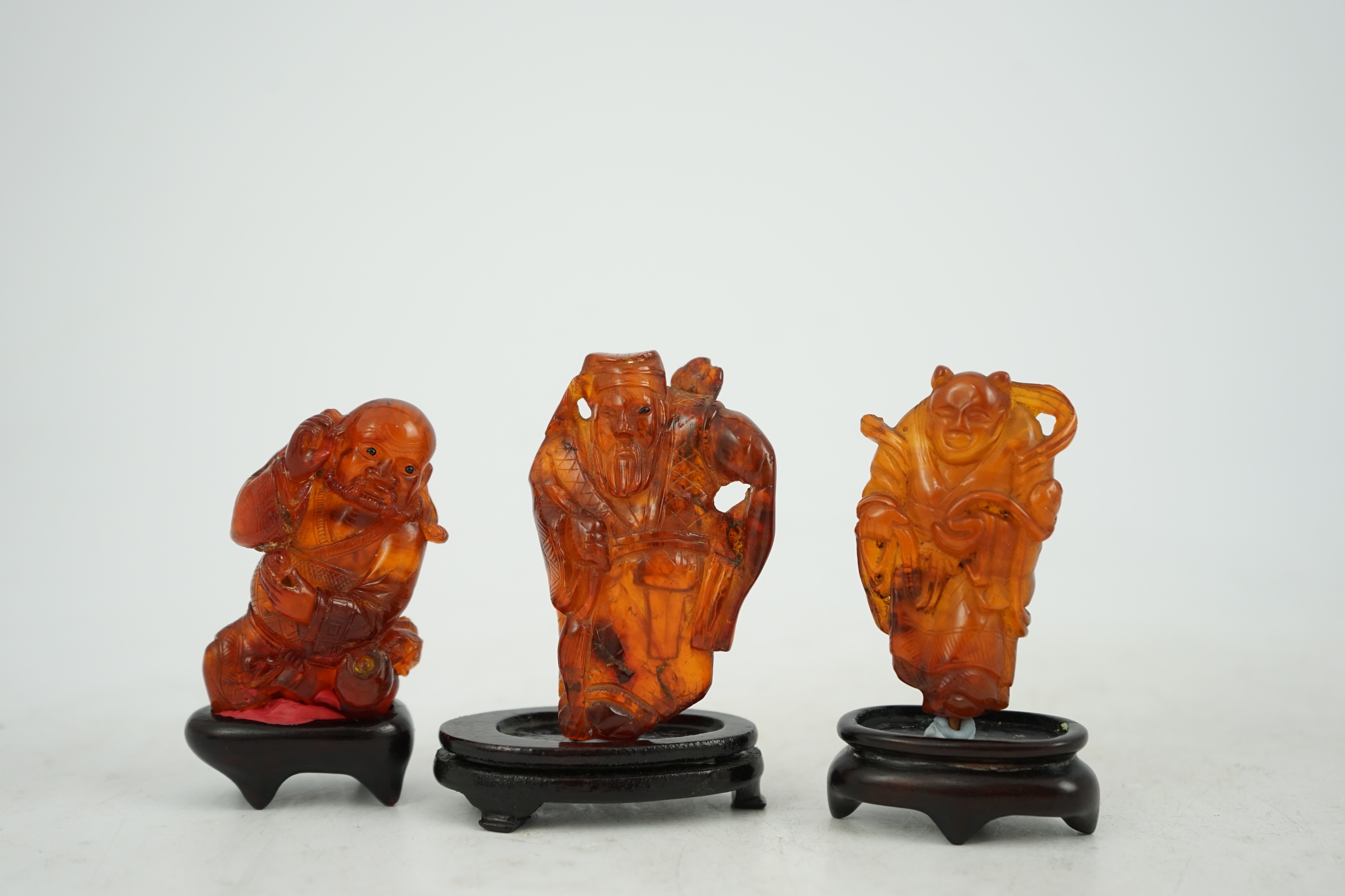 Three Chinese amber figures of immortals, 19th century